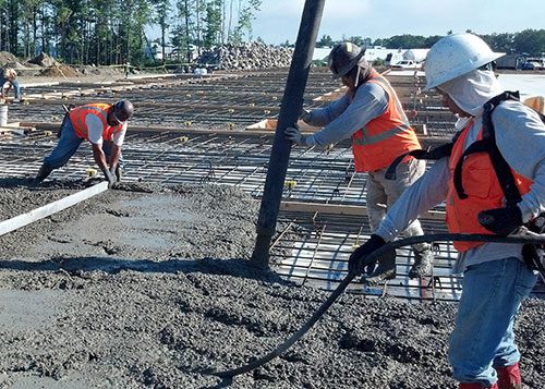 A Group of Construction Workers Pouring Concrete
